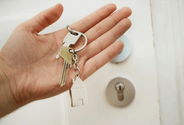 Homeowner holding keys in front of a door